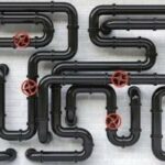 Black plastic pipes with red valve fittings, showcasing essential plumbing infrastructure by B&L Plumbing.
