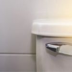 Modern toilet with chrome handle in a clean, minimalist bathroom, showcasing B&L Plumbing's focus on functionality.