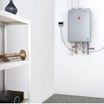 Modern gas water heater on white shelf with trombone, showcasing B&L Plumbing's water heater expertise in Colorado Springs.