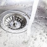 Stainless steel kitchen sink with flowing water, showcasing professional plumbing maintenance by B&L Plumbing.