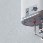 Metallic tankless water heater with red and blue valves and control panel for efficient home plumbing solutions.
