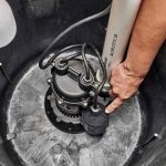 Submersible pump in sump pit with cables, illustrating B&L Plumbing's maintenance for spring drainage solutions.