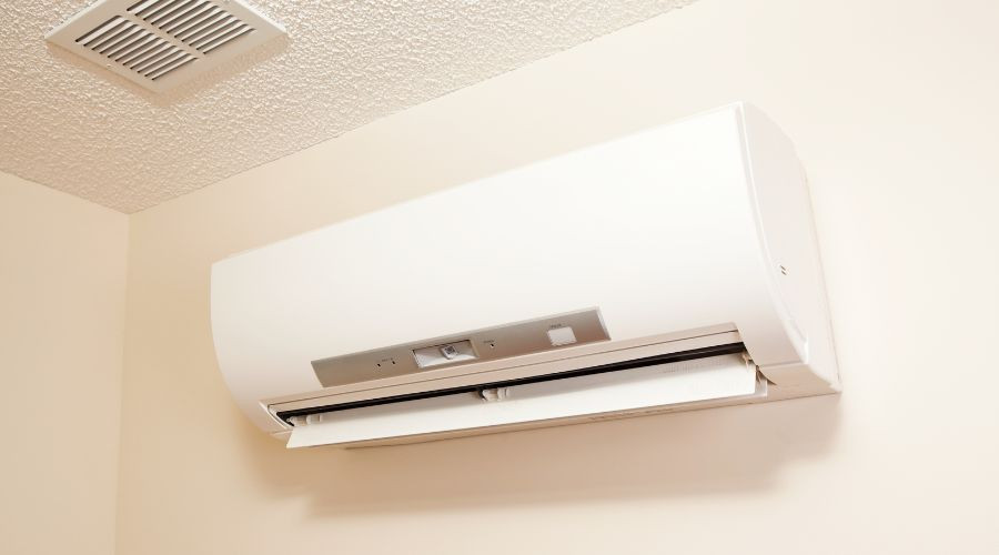 Sleek wall-mounted air conditioning unit with control panel, provided by B&L Plumbing for efficient climate control.